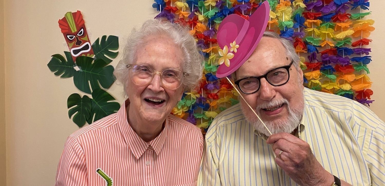 Senior Couple smiling and wearing party hats 