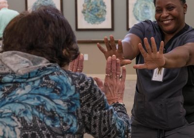 Community resident giving double hi-fives to caregiver