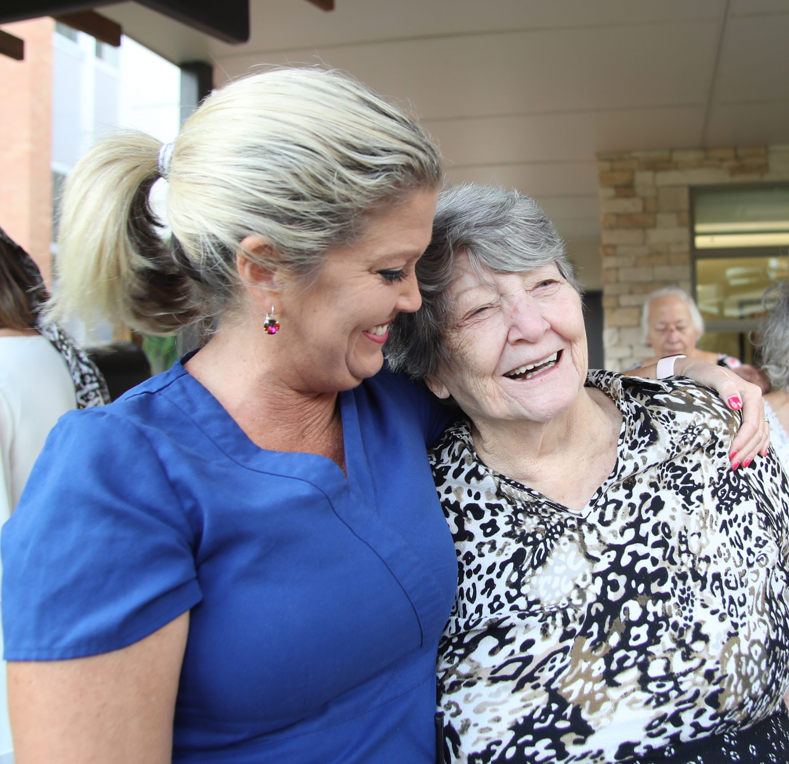 A40I5745 crop Abe's Garden Community Caregiver embracing Abe's Garden Club member