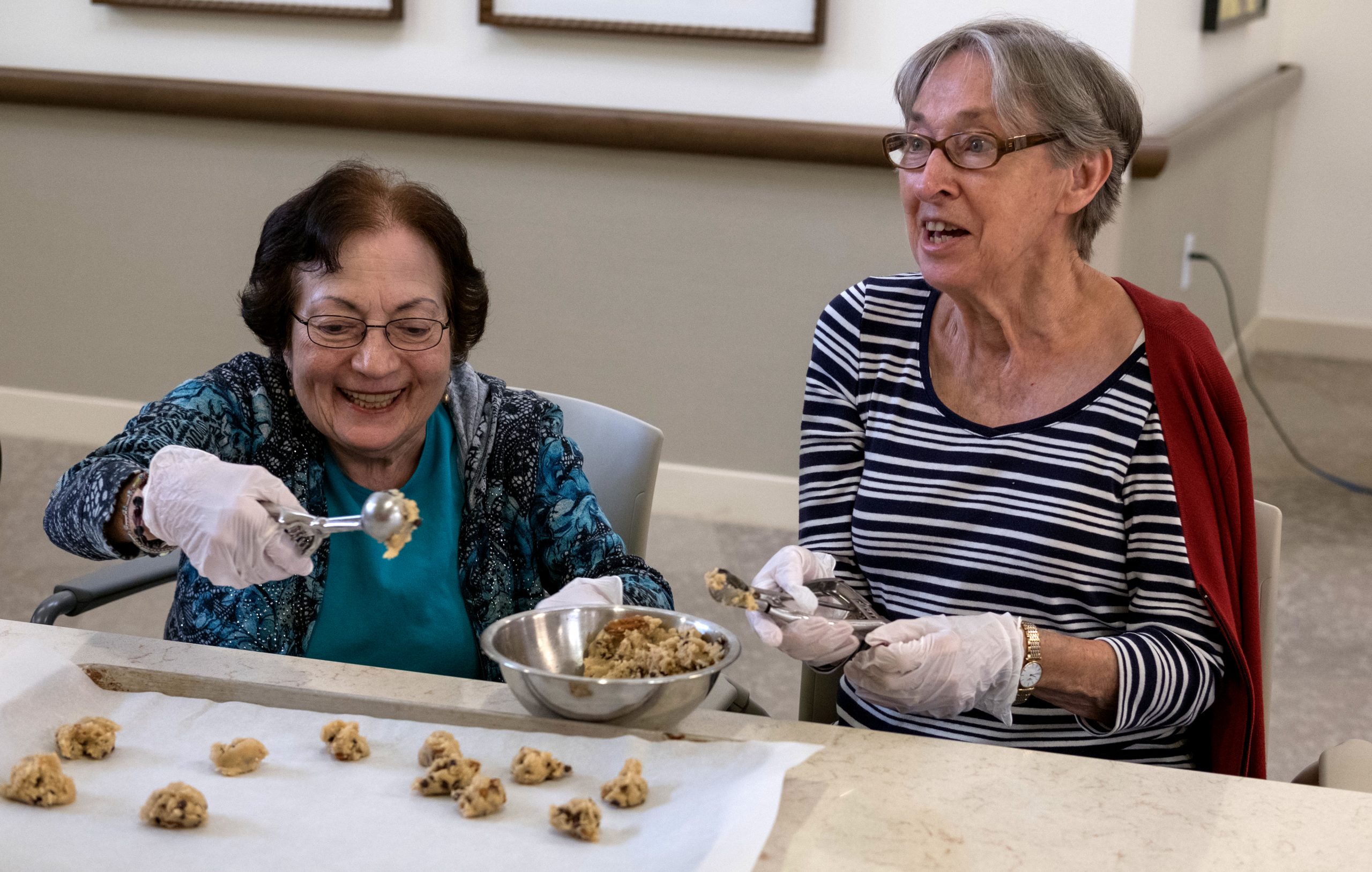 Cooking club Two female cooking club residents baking cookies and smiling