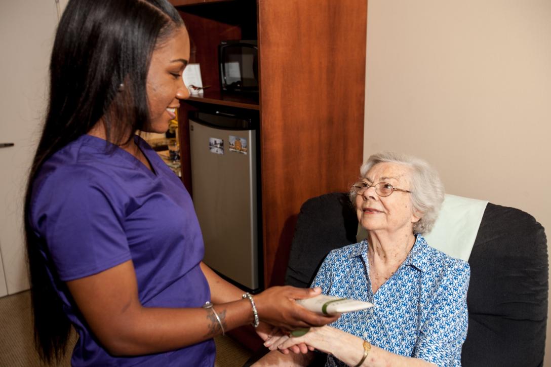 caregiver giving hand massage to senior resident