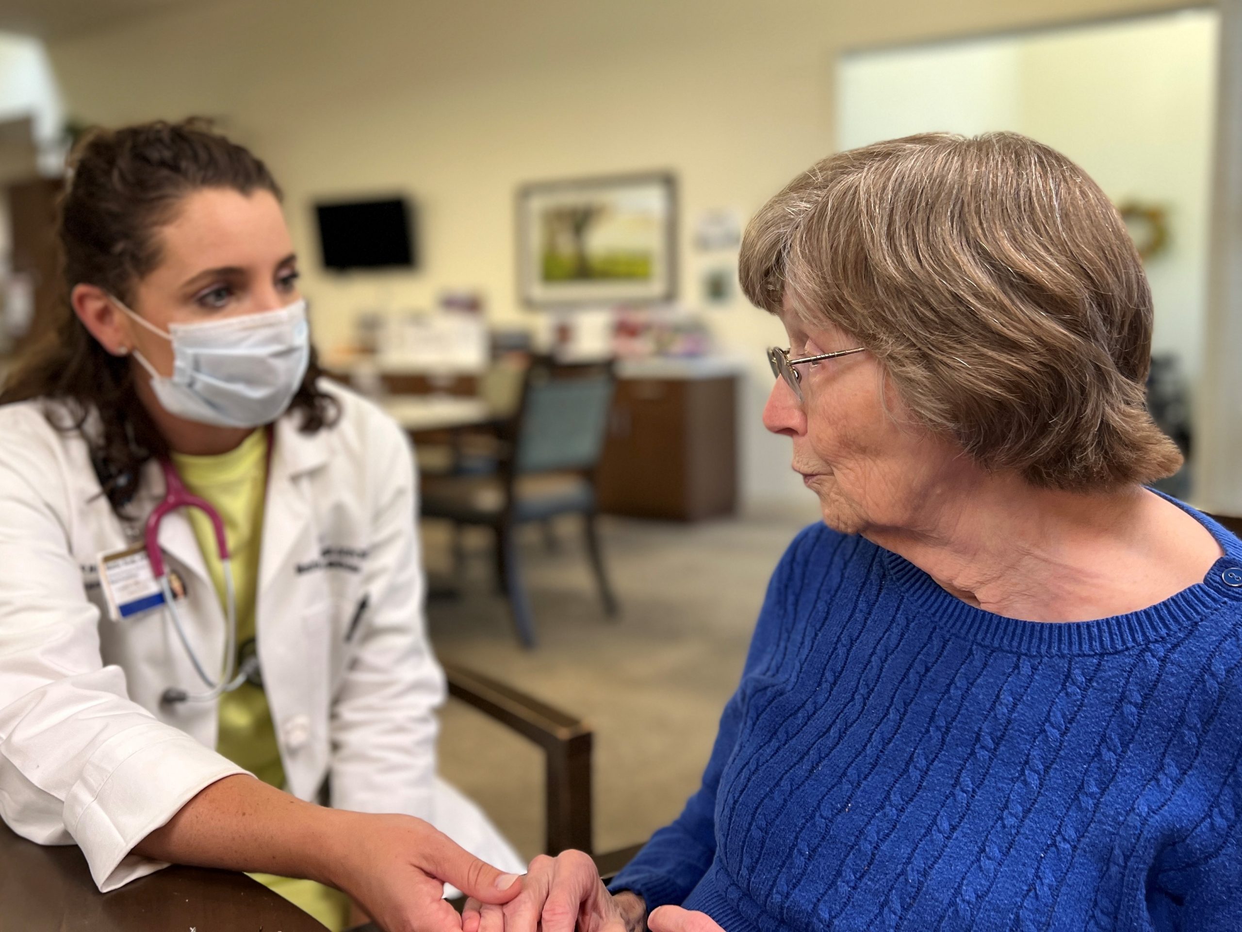 Nurse practitioner Mattie Brady holding the hand of an elderly woman