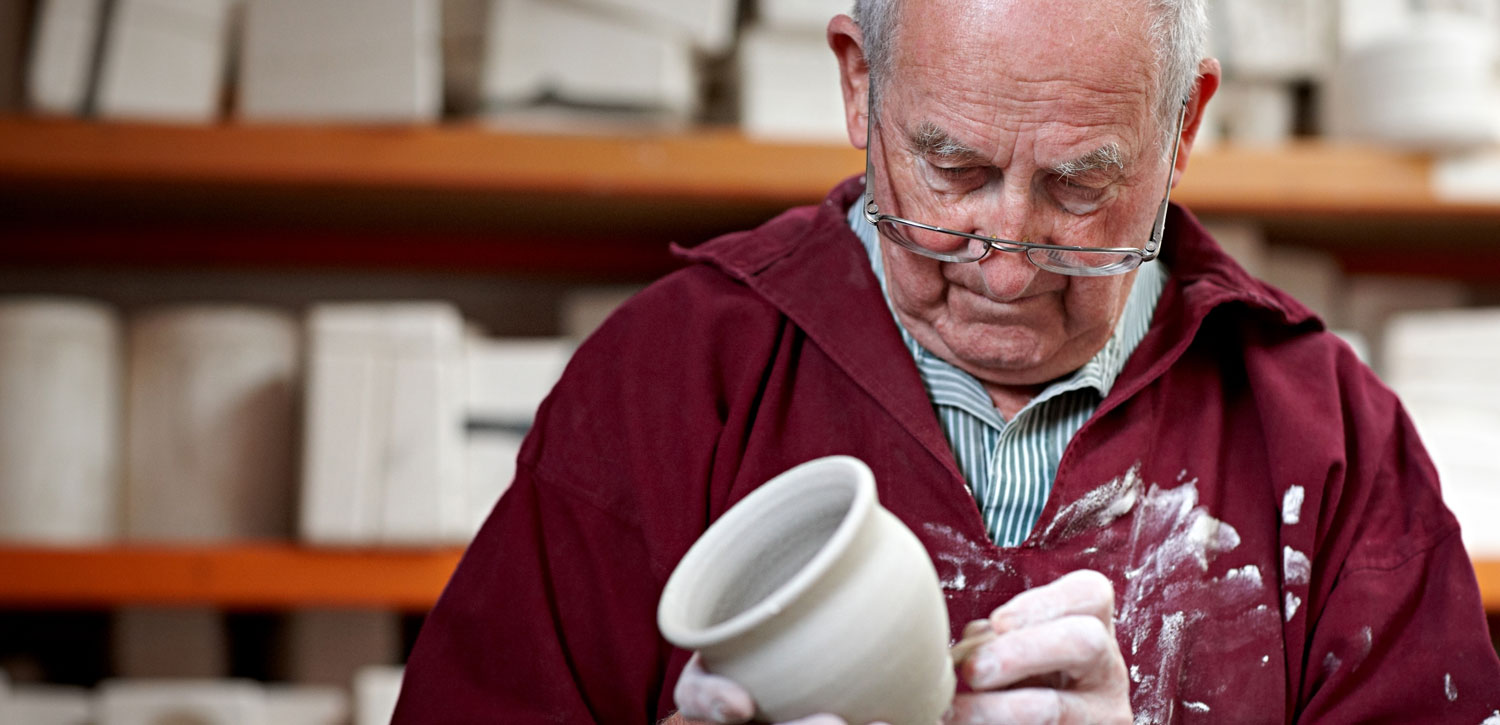 Senior aged man molding a pot