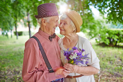 Senior Aged husband and wife, wearing hats, standing close together