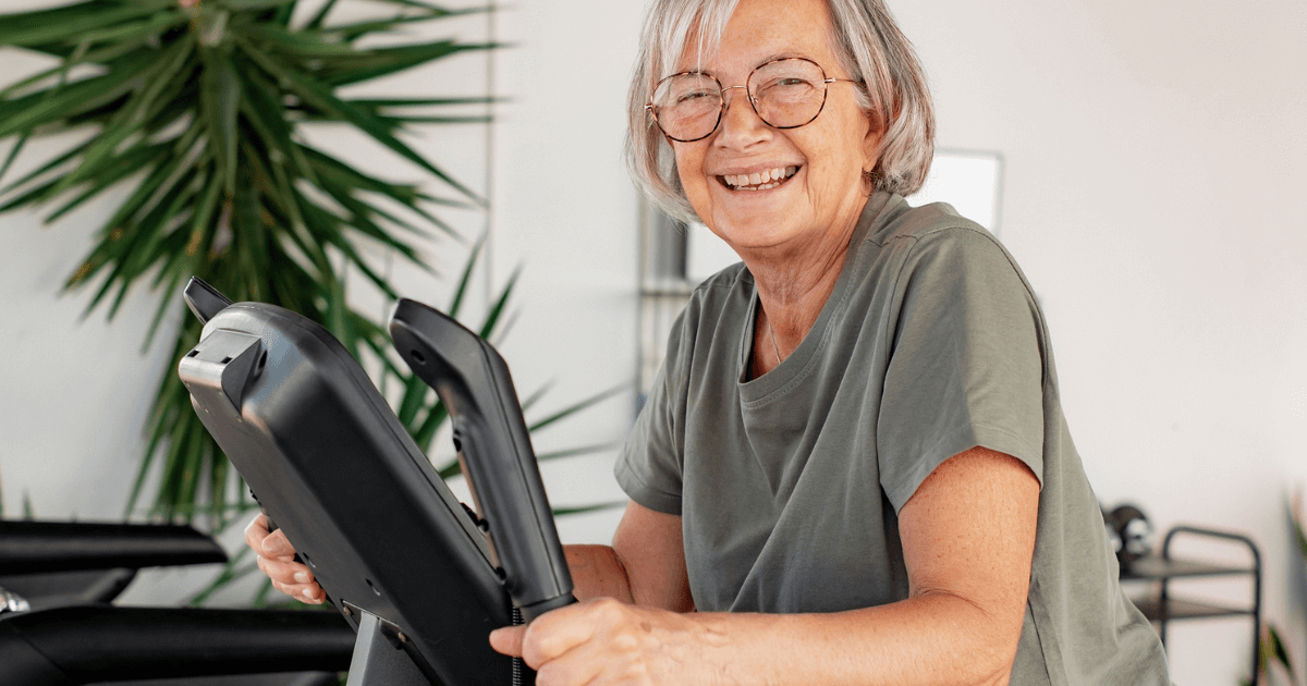 Elder woman on exercise machine displaying an example of how senior living residents spend their time.