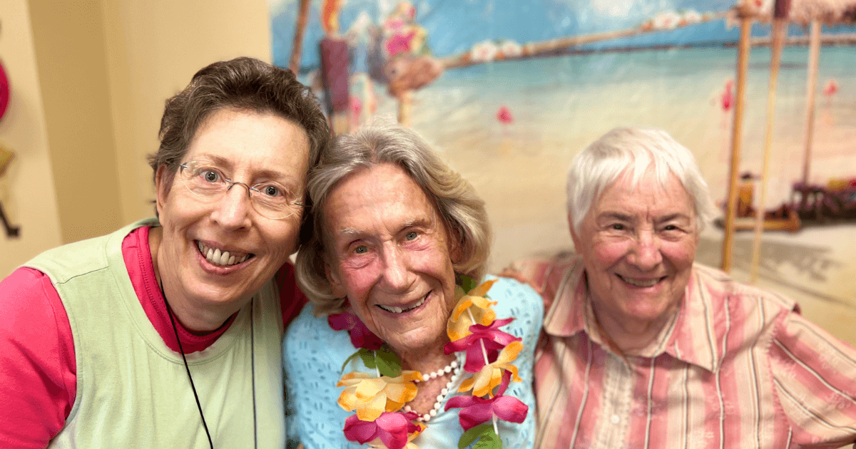 Three elder women gathered proving strong social life protects the health and wellness of seniors.