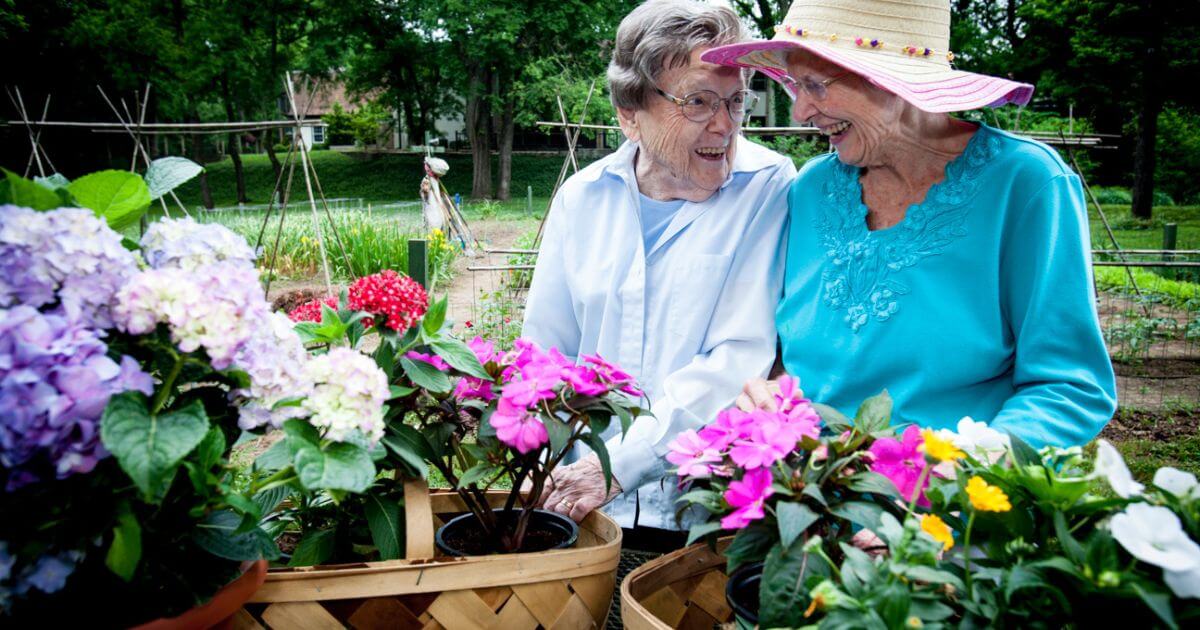 Two senior woman gardening their flowers during retirement.